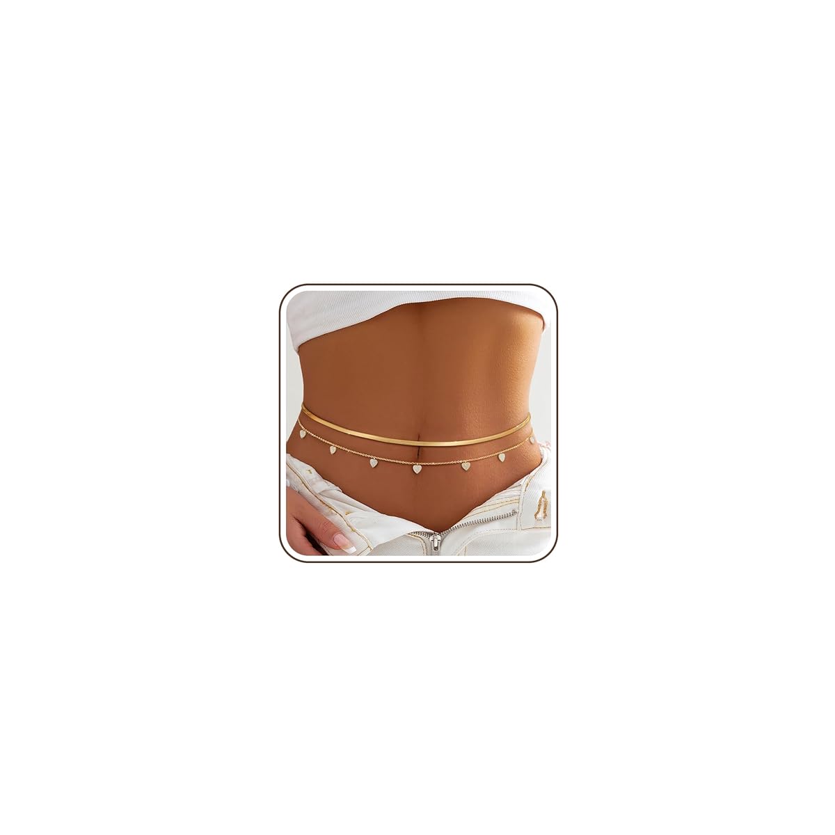 Deux chaînes de taille dorées avec pendentif amour et détails en zircone, posées sur une pierre claire.