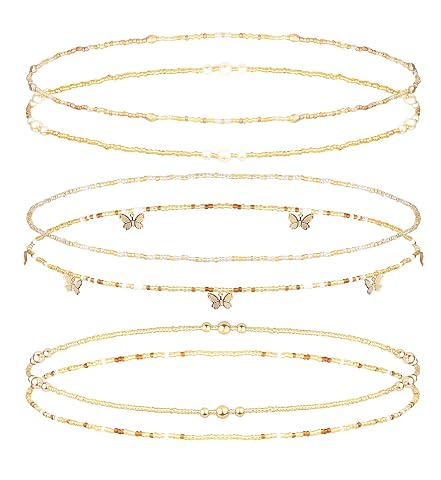 Six chaînes de taille en perles d’imitation blanc ou crème disposées séparément sur une pierre claire