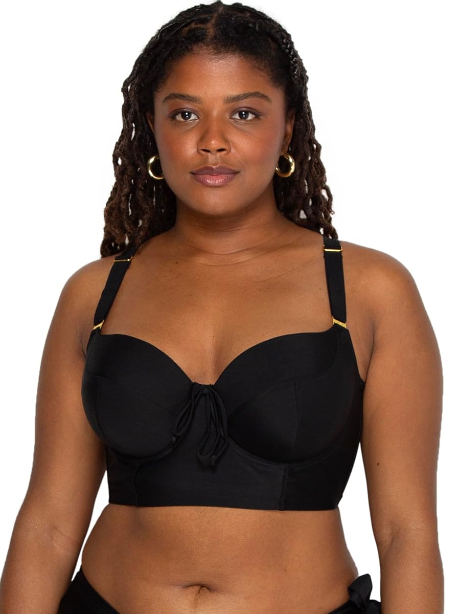 Haut de bikini noir à armatures, posé sur pierre claire avec ses bonnets trois pièces et ses bretelles réglables.
