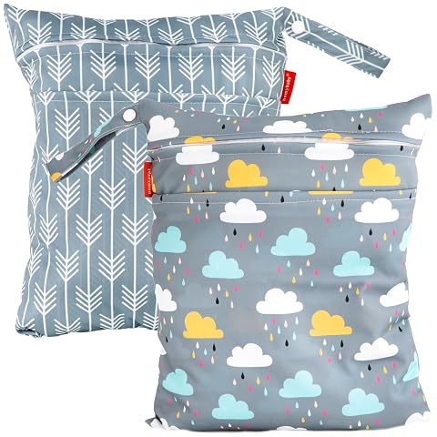 Deux pochettes textiles imprimées avec fermetures éclair et boucles, posées sur du lin clair.